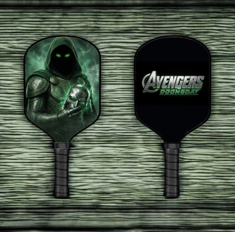 Two pickleball paddles with a green character design and Avengers logo on a textured surface