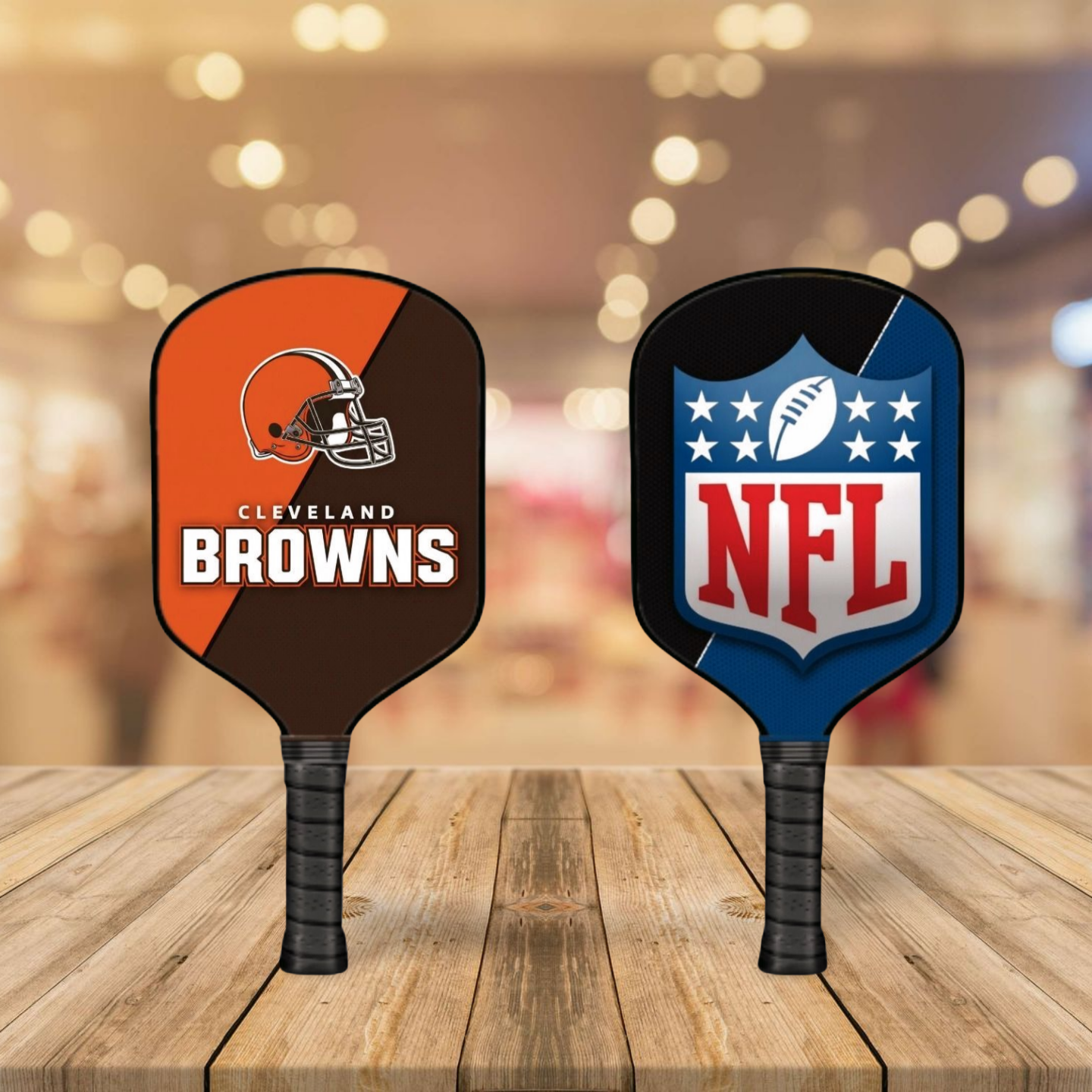 Two pickleball paddles with Cleveland Browns and NFL logos on a wooden surface.