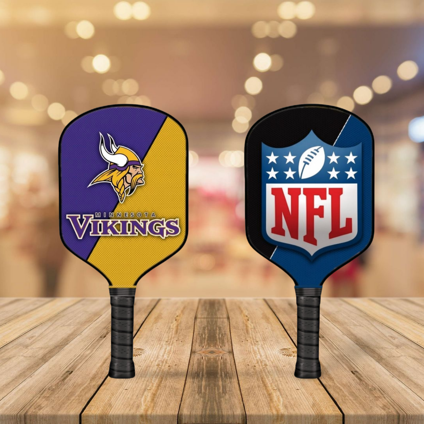 Two pickleball paddles with Minnesota Vikings and NFL logos on a wooden surface.