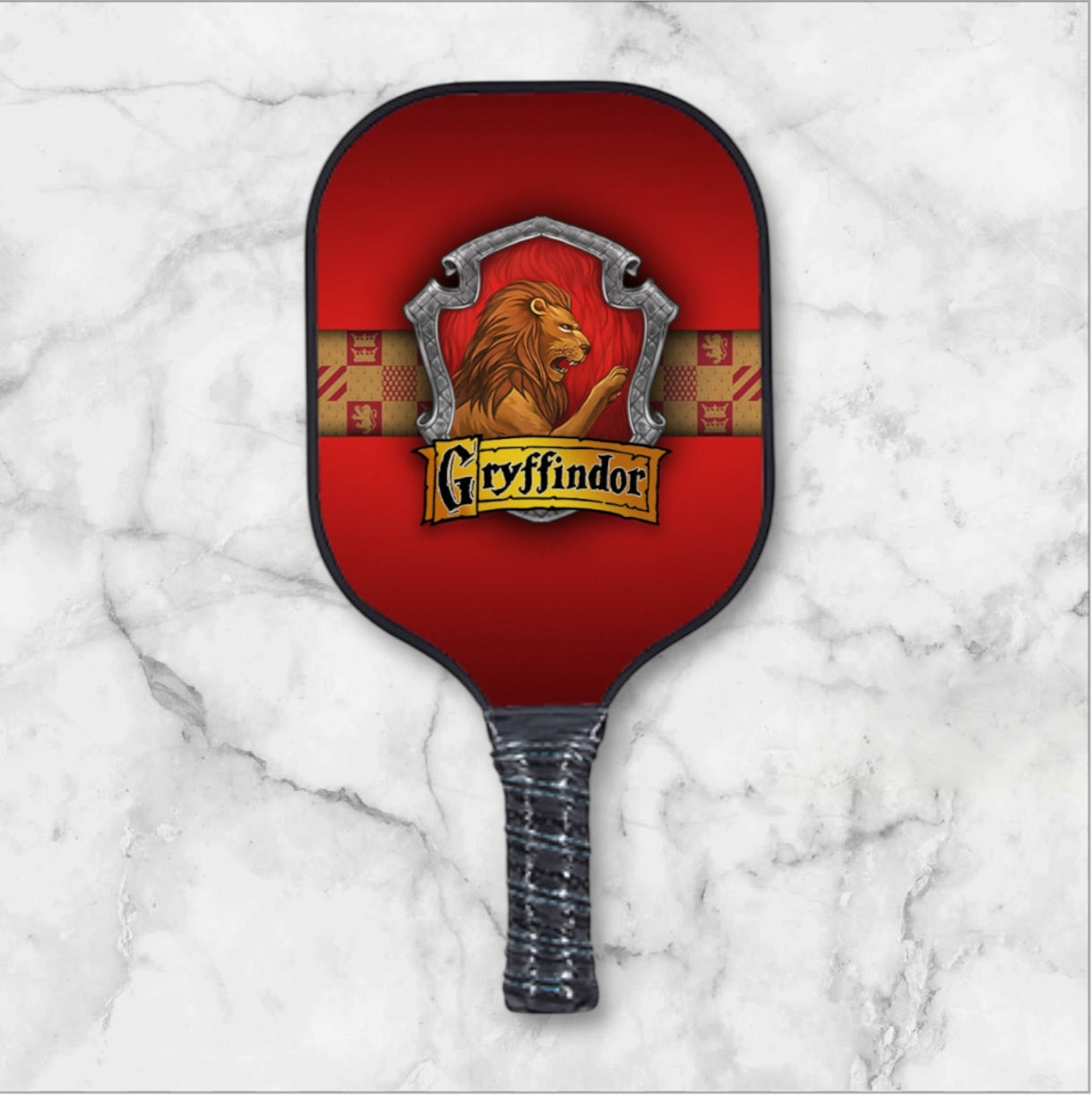 Red paddle with Gryffindor logo on a marble background