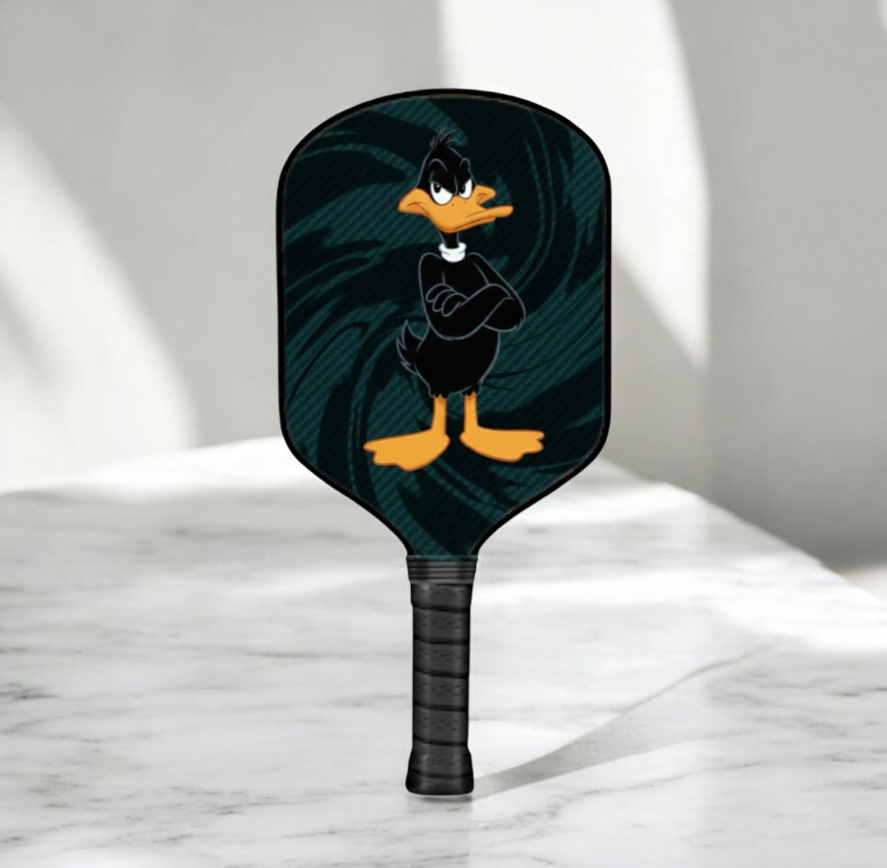 Pickleball paddle with cartoon character design on a marble surface