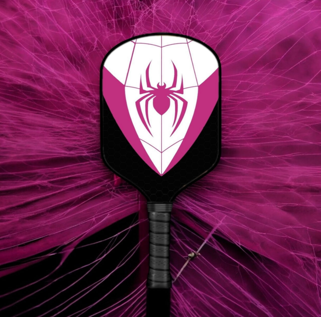 Pickleball paddle with spider web design on a pink abstract background