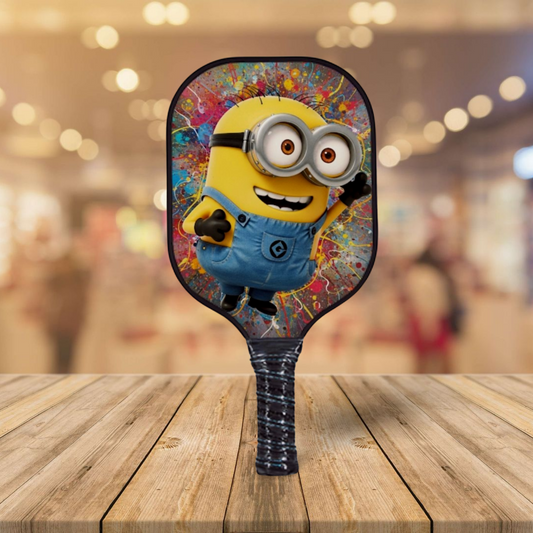 Pickleball paddle with a colorful minion design on a wooden surface