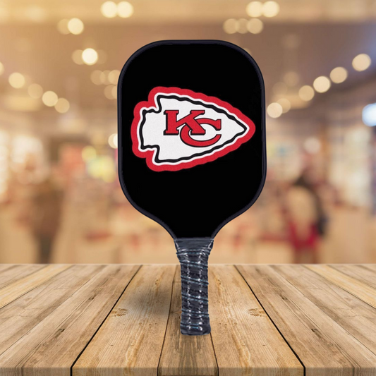 Pickleball paddle with Kansas City Chiefs logo on a wooden surface