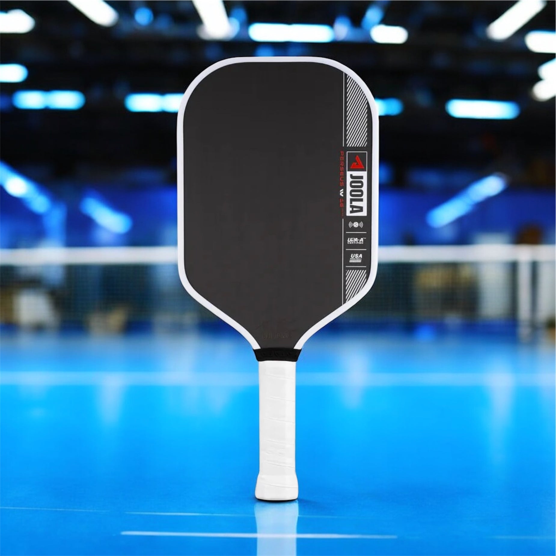 Black pickleball paddle with white handle on a blurred indoor court background