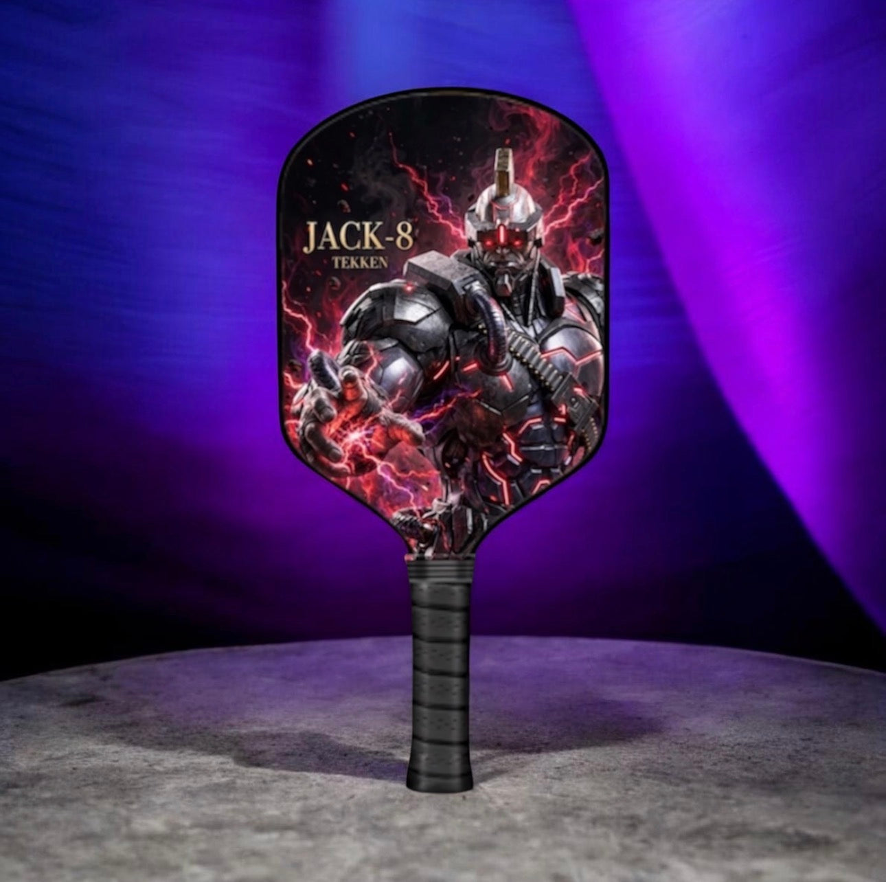 A paddle-shaped hand fan featuring a printed graphic of the Jack-8 character from the movie Terran, standing upright on a gray surface against a purple and blue studio background.
