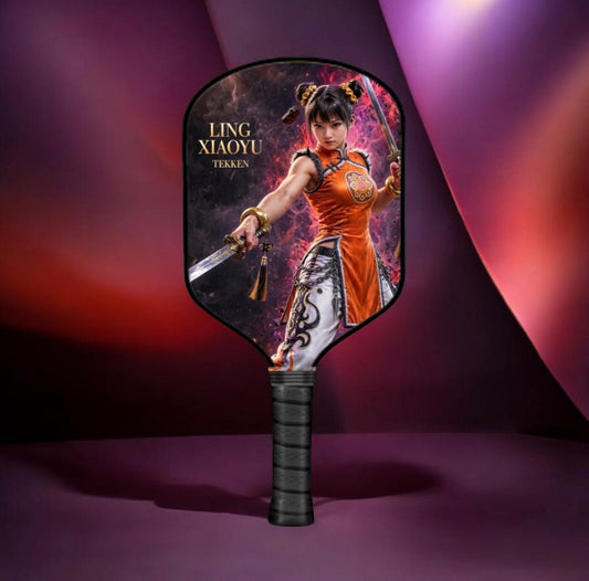 A paddle-style hand fan featuring an illustrated character labeled 'LING XIAOYU TEIKEN' on a dark, dramatic purple and red studio background.