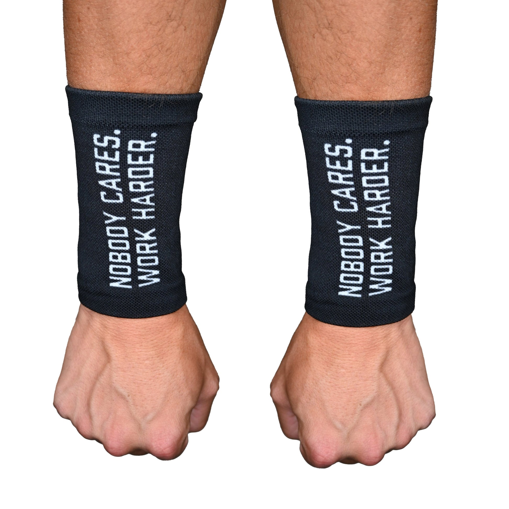 Black wrist wraps with 'Nobody Cares. Work Harder.' text on a white background